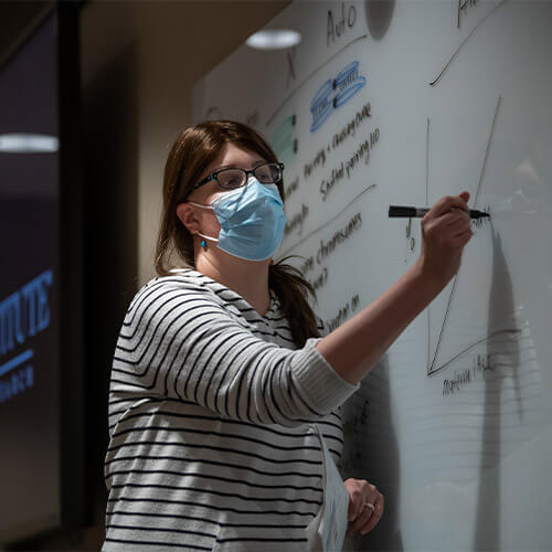 Woman writing on whiteboard