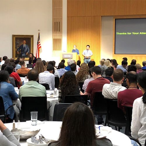 Person presenting to a group at an event