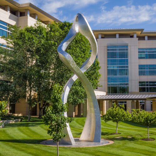 Photo of a shiny double helix statue on the grounds of the Stowers Institute