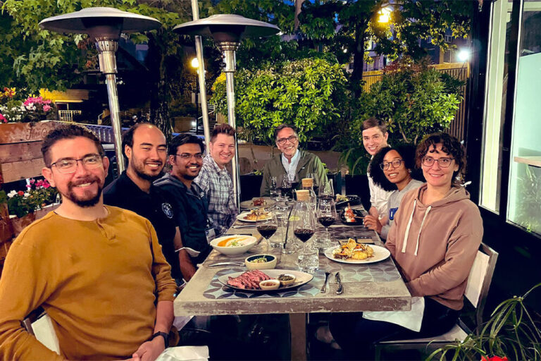 Group of people enjoying an evening meal outside at a restaurant