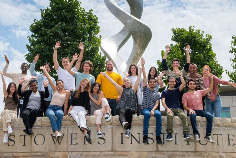 Group of summer scholars waving